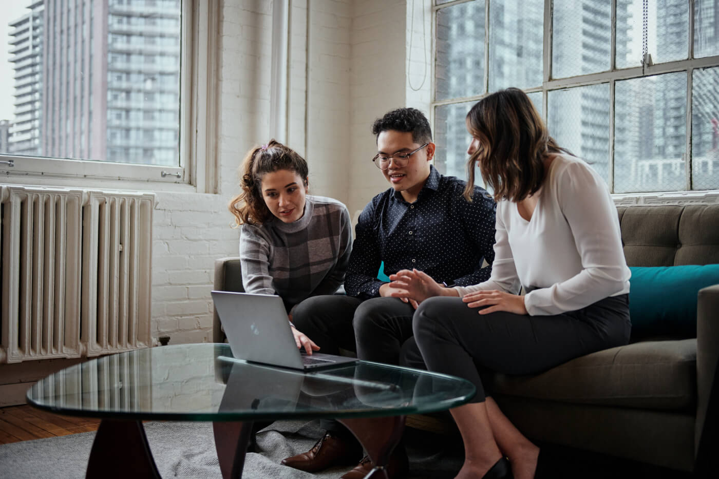 Three members of the Nimbus team reviewing a laptop together